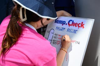 A person records the temperature at the state fair